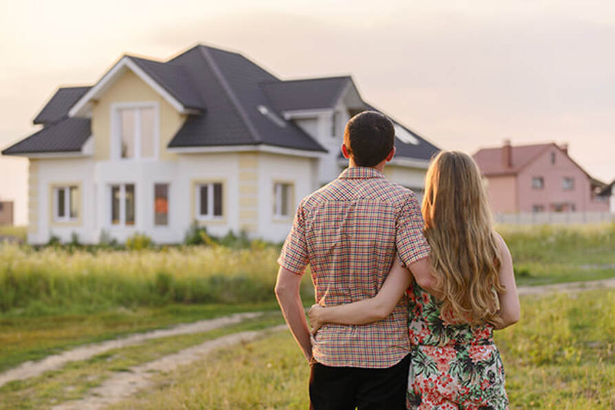 A couple looking at a home from outside. Bridge loan options.